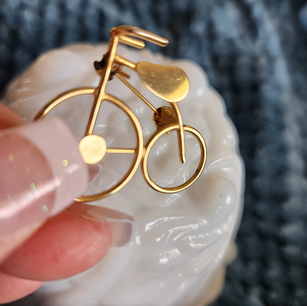 A gold tone antique bicycle pin